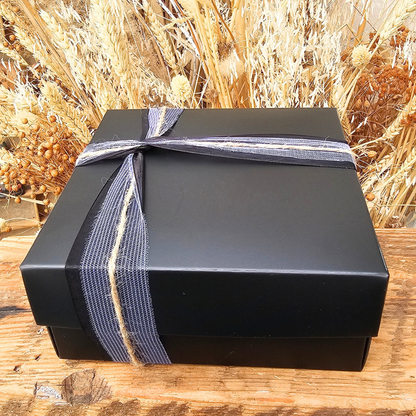 Gesloten zwarte cadeaudoos van Cadeauset Bosuil afgewerkt met paars-zwart lint
